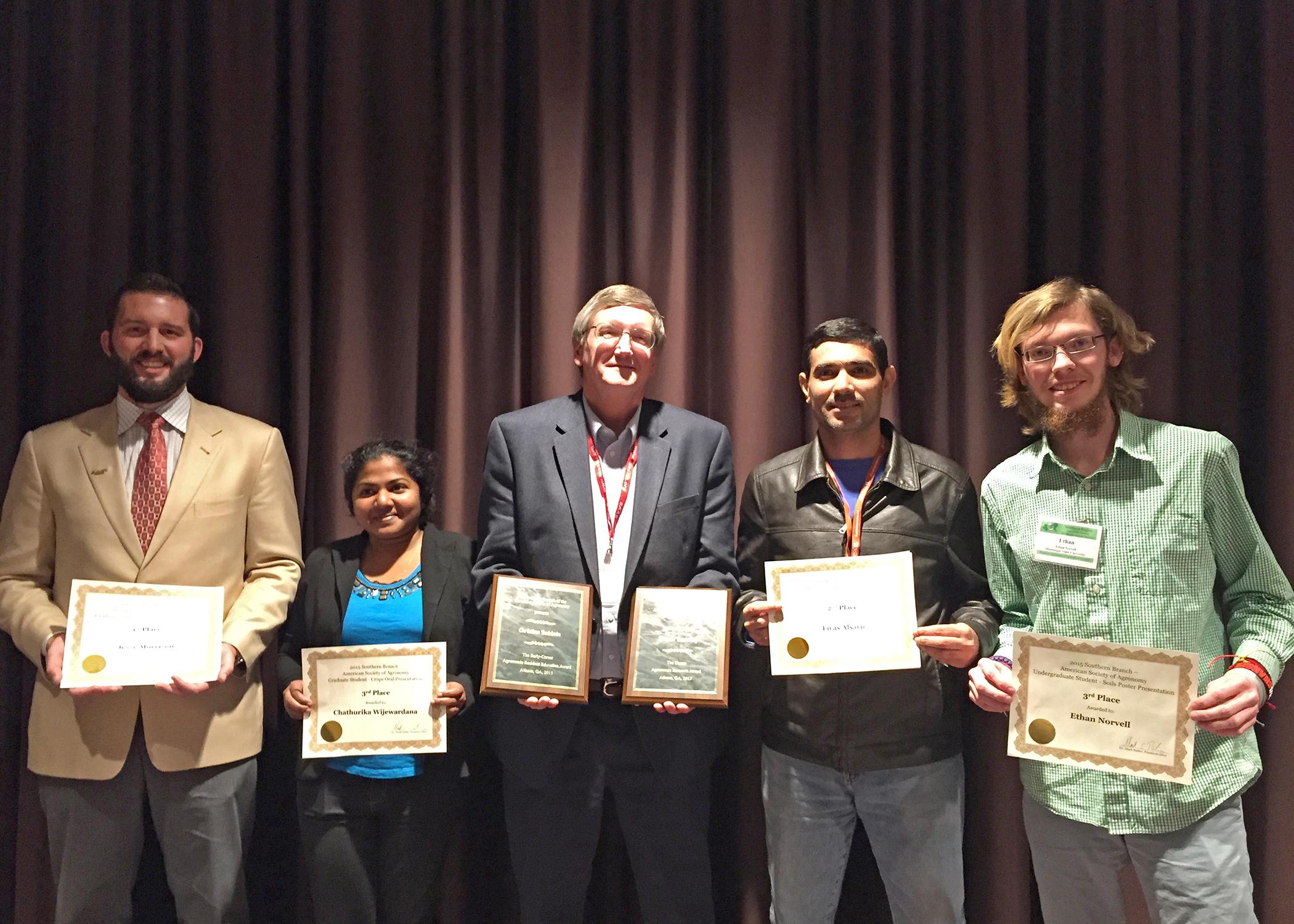 Mike Phillips, center, head of the Mississippi State University Department of Plant and Soil Sciences, joins faculty members and students from his department displaying awards received during a recent meeting of the Southern Branch of the American Society of Agronomy. Pictured are (from left to right) Jesse Morrison, doctoral student; Chathurika Wijewardana, master's student; Phillips (holding awards for Normie Buehring and Christian Baldwin); Firas Alsajri, doctoral student; and Ethan Norvell, undergraduat