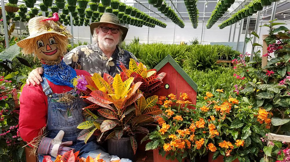 Southern Gardening host Dr. Gary Bachman in greenhouse with scarecrow.