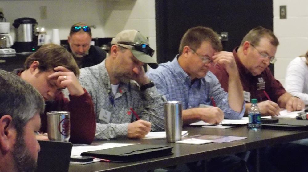 Agents seated at table taking notes during training.