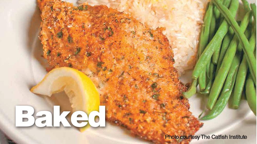Close-up photo of baked, breaded catfish served on a plate with white rice, green beans and a slice of lemon