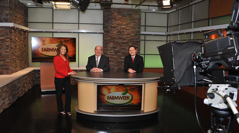 a woman and 2 men at the anchor desk in the Farmweek TV studio.