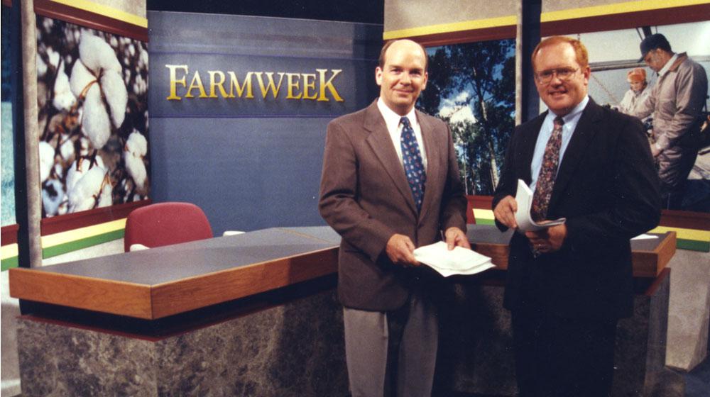 2 male anchors in front of Farmweek TV studio desk