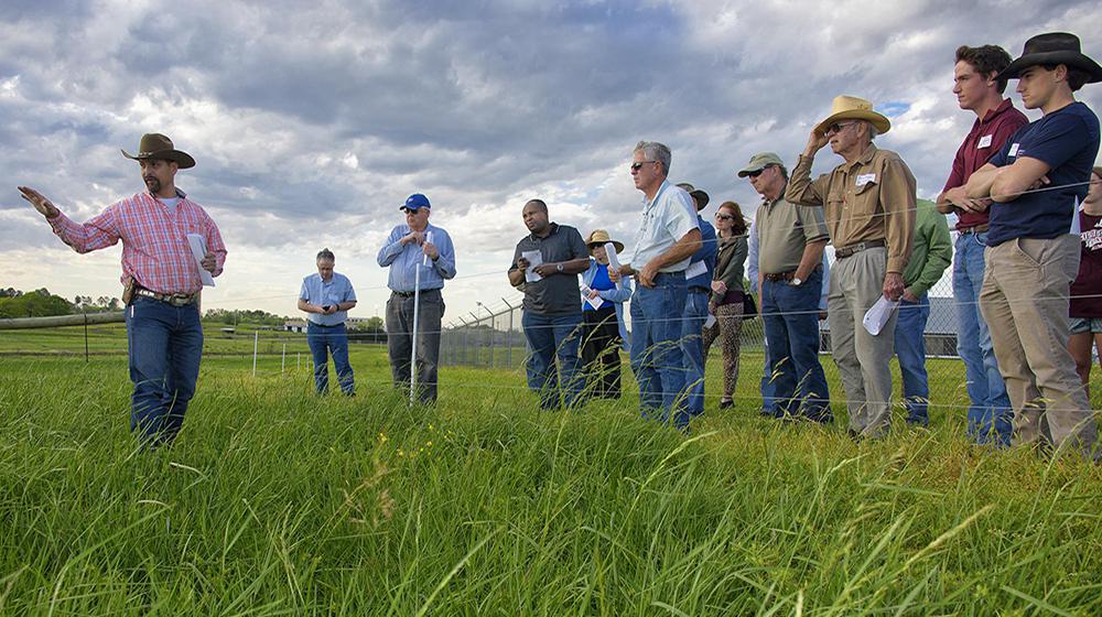 Rocky Lemus instructs a group of people in a field.