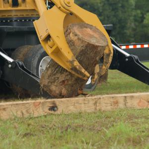 A loader claw squeezing a log.