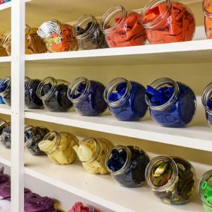 Three shelves of colorful balloons in clear, plastic holders.