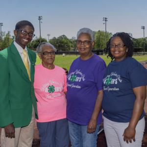 Four people standing outside on a running track. 