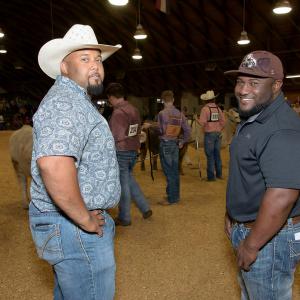 Two men stand together in the livestock show ring at the Mississippi State Fair. 