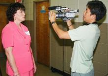 Danette Blackwell, a business and computer technology teacher at Hattiesburg High School, answers questions on camera for Sunghan Lee, a television producer from South Korea. Lee was taping for a documentary he is preparing on financial education for young people.