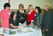 Susan Cosgrove (seated), area family resource management agent for Mississippi State University's Extension Service, reviews personal finance curricula with teachers (from left) Danette Blackwell of Hattiesburg High School; Helen Motes and Sheri White, both of Stone High School; Elizabeth Ellzey of Hattiesburg High School; and Carol Thomas of Pascagoula Applied Technology Center. The teachers were taking part in a "Money Matters" seminar in Hattiesburg for high school students and their teachers.