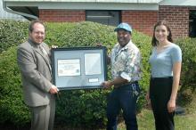 Alan E. Gerald, left, of the National Weather Service in Jackson, presented MSU a framed certificate of honor and a replica of the August 1888 weather data reported by then Mississippi A&M. Receiving the certificate is Carl Blair. Program leader Carolyn L. Bryant observes.