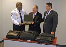 Dr. Vance Watson, MSU Extension Director, presents a used computer to Bolton Police Chief Michael Williams. Watson presented the equipment with Jay Ledbetter, director of the Mississippi Department of Homeland Security. (Photo by Ned Browning)