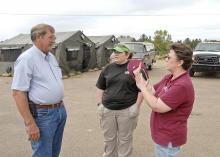 Choctaw County supervisor Archie Collins, left, discusses the day's schedule with MSU Extension Service food and nutrition assistant Dee Ann Williams and volunteer Ashley Williams at the Mill Springs disaster response center in Choctaw County. (Photo by Bob Ratliff)