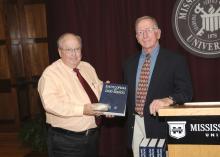 Mississippi State University professor emeritus John Fuquay (right) presents a copy of the first edition the Encyclopedia of Dairy Science and a CD-ROM of the second edition to Terry Kiser, head of MSU's animal and dairy sciences department. Fuquay was recently honored for his work as editor-in-chief of the second edition of the encyclopedia. (Photo by Scott Corey)