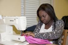 Constance Crockett of Hattiesburg puts the finishing touches on a dress she made in the Apparel Design I class at Mississippi State University's School of Human Sciences for the nonprofit charity Little Dresses for Africa.