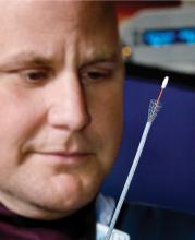 Dr. Todd Archer examines a tracheal stent and accompanying stylet, which allows passage of the stent into the proper location in the dog's windpipe. (Photo by MSU College of Veterinary Medicine/Tom Thompson)