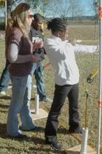 Leanne Wagner McGee, Newton County Extension agent, looks on as Nia McCalphia and Jemariaus Ford prepare to shoot arrows at their targets during the Wildlife Youth Day at the Coastal Plains Experiment Station Nov. 16. (MSU Ag Communications/Susan Collins-Smith)