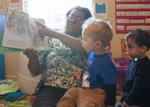 Child-care provider Dana Smith reads a book to Levi Mills and Jakob Reyes during story time at her in-home child-care program in Olive Branch. Busy Bundles of Joy Learning Center was recently recognized as a 5-star center by the in-home Quality Rating and Improvement System. (Photo by MSU Extension Service/Alicia Barnes)
