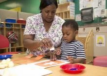 Penny Lee, a teacher at Global Connection Learning Center in Jackson, helps 2-year-old Jacob Sargent with an art project. Early care and education providers like Lee will be honored on Provider Appreciation Day May 10. (Photo by MSU School of Human Sciences/Alicia Barnes)