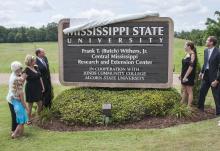 About 200 former colleagues, friends and family members attended the dedication of the Frank T. (Butch) Withers Jr. Central Mississippi Research and Extension Center held July 10 in Raymond. Withers' family members Jaidyn Laird, Caroline Withers, Shelly Withers and Elizabeth Kilgore, along with Mississippi State University President Mark Keenum (at left) and Vice President of the Division of Agriculture Forestry and Veterinary Medicine Greg Bohach, look on as the new sign is revealed. (Photo by MSU Ag Commu