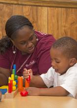 Mississippi State University Extension Service employee Tiffini Nash plays with a child on May 16, 2014, at Destiny's Day Care in Louisville, Mississippi, as part of disaster recovery assistance that included materials, supplies and personnel. (Photo by MSU School of Human Sciences/Alicia Barnes)