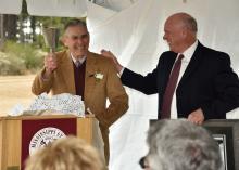 E.G. "Gene" Morrison, left, rings the engraved cowbell given to him by George Hopper, director of the Mississippi State University Mississippi Agricultural and Forestry Experiment Station on Nov. 20, 2014, at the Brown Loam Branch Experiment Station. The station was renamed in honor of Morrison, who served as station superintendent for 33 years. (Photo by MSU Extension Service/Kevin Hudson)