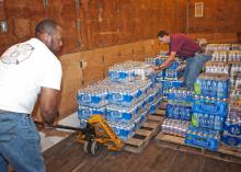 B.J. McClenton, Monroe County Extension coordinator (left), and Charlie Stokes, area Extension agent, unload water from a semi-trailer to distribute to tornado victims in Monroe County in 2011. (Photo by MSU Ag Communications/Scott Corey)