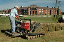 Steve Hughes lays down sod near one of Mississippi State University's new residence halls.  Hughes Sod Installation, of Lee County, placed about 10,000 yards of sod on the campus the week before MSU hosts the first football game of the 2007 season.  (Photo by Linda Breazeale)