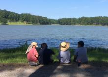 Four buddies enjoy a break overlooking Choctaw Lake in the Tombigbee National Forest near Ackerman, Mississippi. (Photo by MSU Extension Service/Evan O’Donnell)