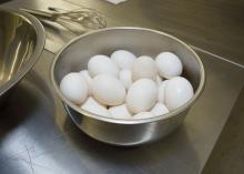 Several eggs sit in a bowl on a kitchen counter.