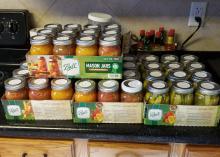 Glass canning jars filled with vegetables fill four boxes.