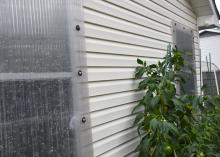 A clear panel covers a window on the exterior of a house.