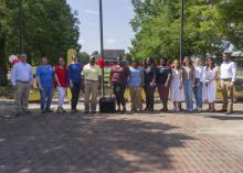 A group of people stand in an outdoor patio area.