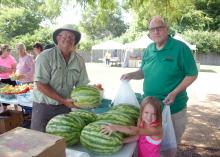 Chickasaw County farmer James Earnest (left) of Prospect Produce Farm sells some of his first watermelons to Dalton Anthony and his granddaughter, Emily Grace Barnette, at the Starkville Community Market on June 21, 2016. (Photo by MSU Extension Service/Linda Breazeale)