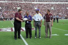 Mississippi State University Extension director Gary Jackson took to the field Sept. 7, 2013, at the MSU home opener to present a commemorative football to visiting Alcorn State University partners. From left are Jackson; Alcorn Extension administrators Dalton McAfee and Anthony Reed; and Gregory Bohach, MSU vice president for the Division of Agriculture, Forestry and Veterinary Medicine. (Photo by MSU Ag Communications/Kat Lawrence)