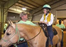 Volunteer Lantz Stewart of West Point offers advice to Eli Barlow before they enter the arena for the first Therapeutic Riding Expo at the Mississippi Horse Park on April 14, 2015. (Photo by MSU Ag Communications/Linda Breazeale)