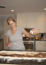 Christa Lee, owner of LoveLee Rolls in Starkville, Mississippi, sprinkles cinnamon on her rolled-out dough on Sept. 30, 2016. She operates her business under the guidelines of the Mississippi Cottage Food Bill. (Photo by MSU Extension Service/Kat Lawrence)