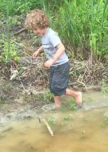 Getting dirty is half the fun for children exploring and playing in the great outdoors. Rain may drive families inside for a time, but they provide some great water features after the thunder and lightning have passed. (Photo by MSU Extension Service/Evan O’Donnell)