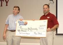 Mike McCain, research and development manager for Mars Food, left, presents a ceremonial $50,000 check to support rice research to Tim Walker, a researcher with the Mississippi Agricultural and Forestry Experiment Station and rice specialist with the MSU Extension Service, in Stoneville, Miss., on July 30, 2013. (Photo by MSU Ag Communications/Linda Breazeale)