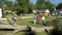 Mississippi State University Extension Service forestry associate John Auel demonstrates proper chainsaw equipment, techniques and apparel to use when removing an uprooted tree in Starkville, Miss., on Tuesday, Sept. 21, 2004. Homeowner Margaret Wade, her daughter, Debbie, and senior forestry major Dan Prevost of Raymond watch from a safe distance as the 50-year-old pecan tree is removed after Hurricane Ivan blew through the area with sustained winds in excess of 50 miles per hour. (AP Photo/Mississippi Sta