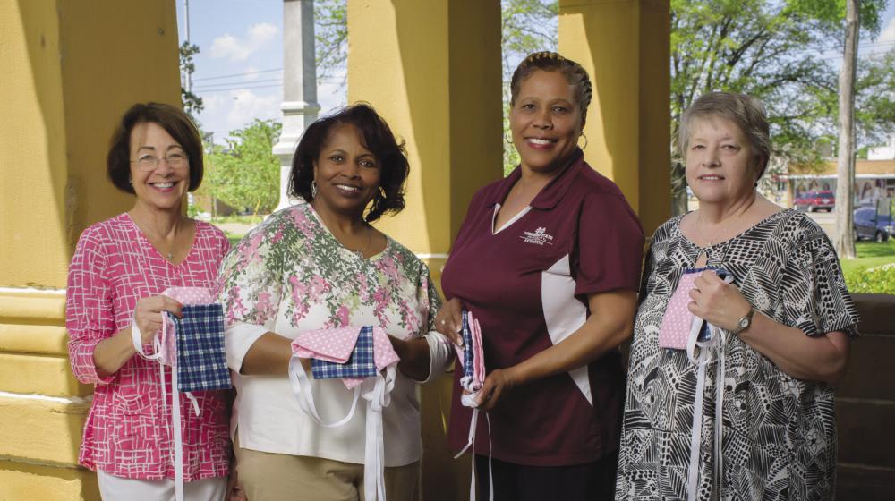 4 women holding mastectomy drain pouch bags—small, square sacks laced with ribbon