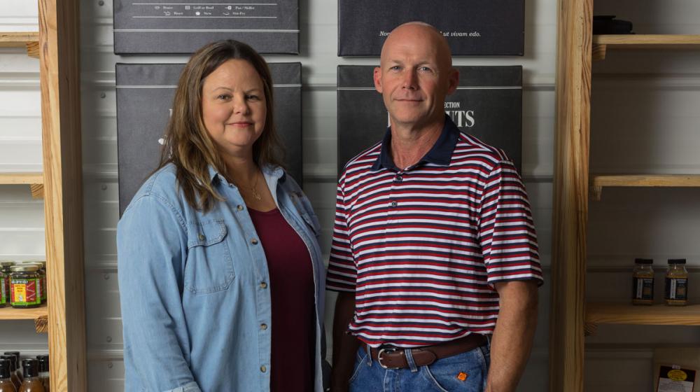 A man and woman standing next to each other, smiling for a photo.