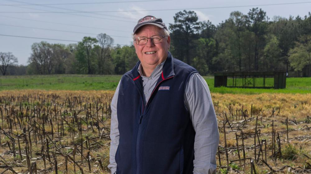 A man standing in a harvested field.