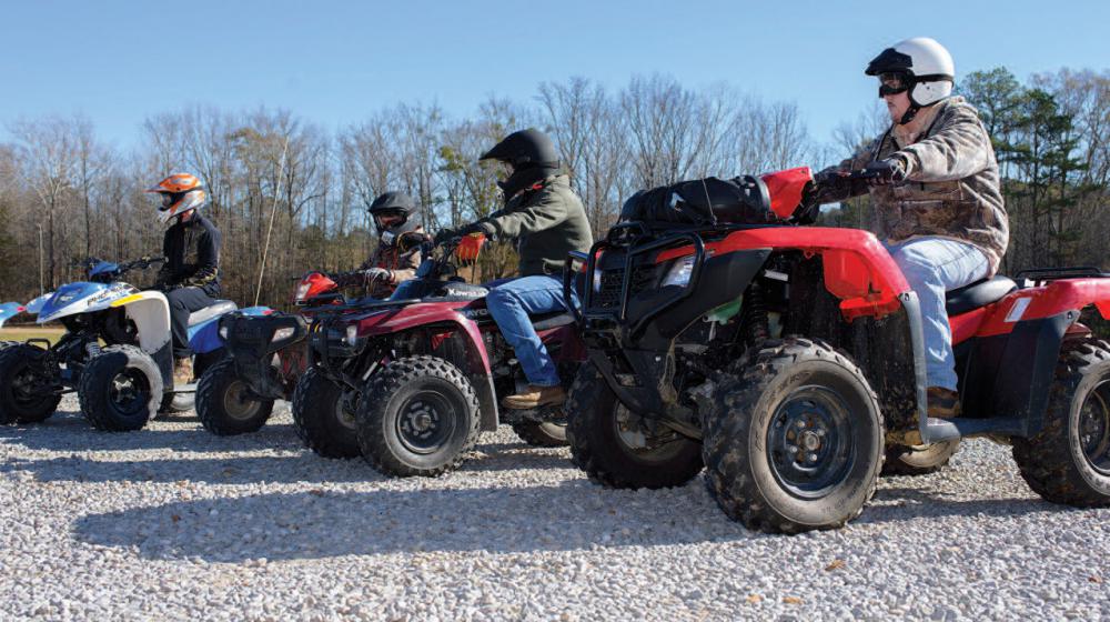 Several men on ATVs lined up.