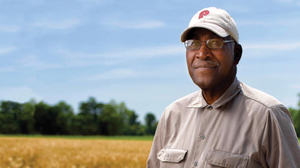 A man standing in a soybean field.