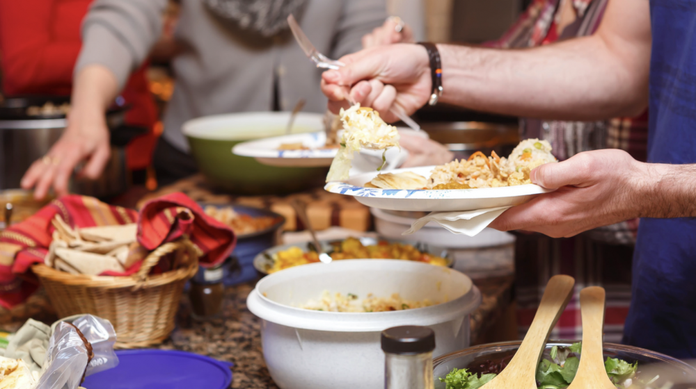 People serve their plates at a buffet-style dinner.