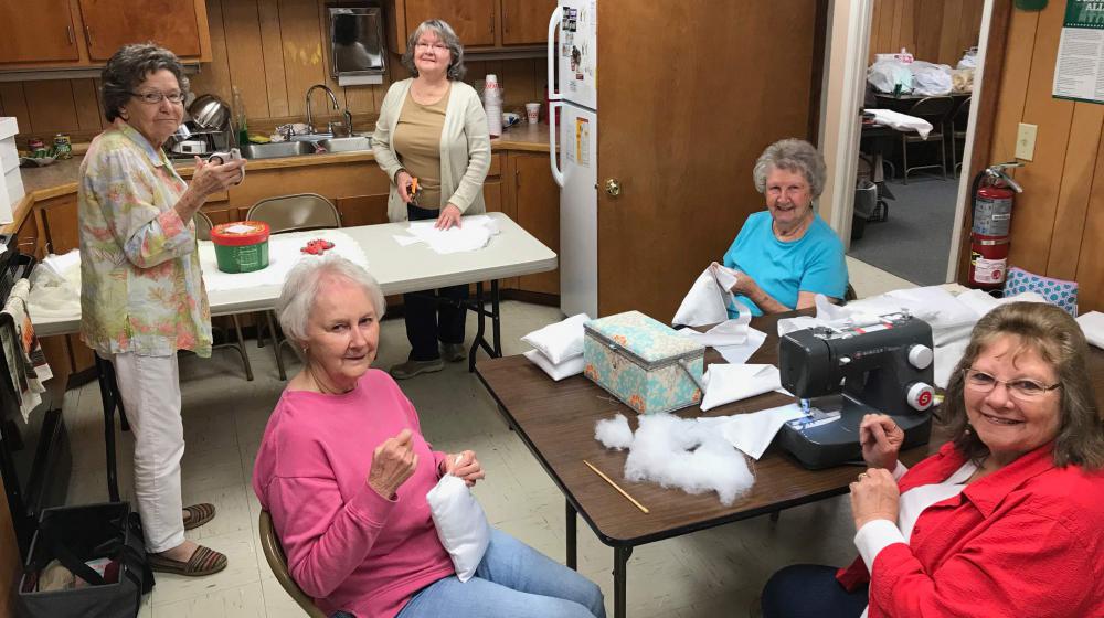 Five women sewing.