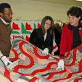 Mississippi State University students Parron Edwards (left), a junior from Lexington, and Shannon Sorro, a senior from Clarksville, Tenn., listen as Wanda Cheek, associate professor of human sciences, discusses the intricacies of quilts and their patterns.