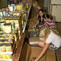 Mississippi State University students, from the front, Elisabeth Brooks, Patrisha Pham, Alessandra Pham and Joan DeSutter sort canned food into boxes for food pantries in Oktibbeha, Clay and Lowndes counties. (Photo by Marco Nicovich)
