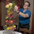 Jim DelPrince fills stacked glass comports with fruit, nuts and cut plant materials to create a stunning but inexpensive holiday centerpiece. (Photo by Scott Corey)