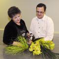 Mississippi State University florist manager Lynette McDougal and horticulture professor Jim DelPrince create a unique wedding arrangement of cymbidium orchids, lily grass, bear grass and feathers. (Photo by Kat Lawrence)